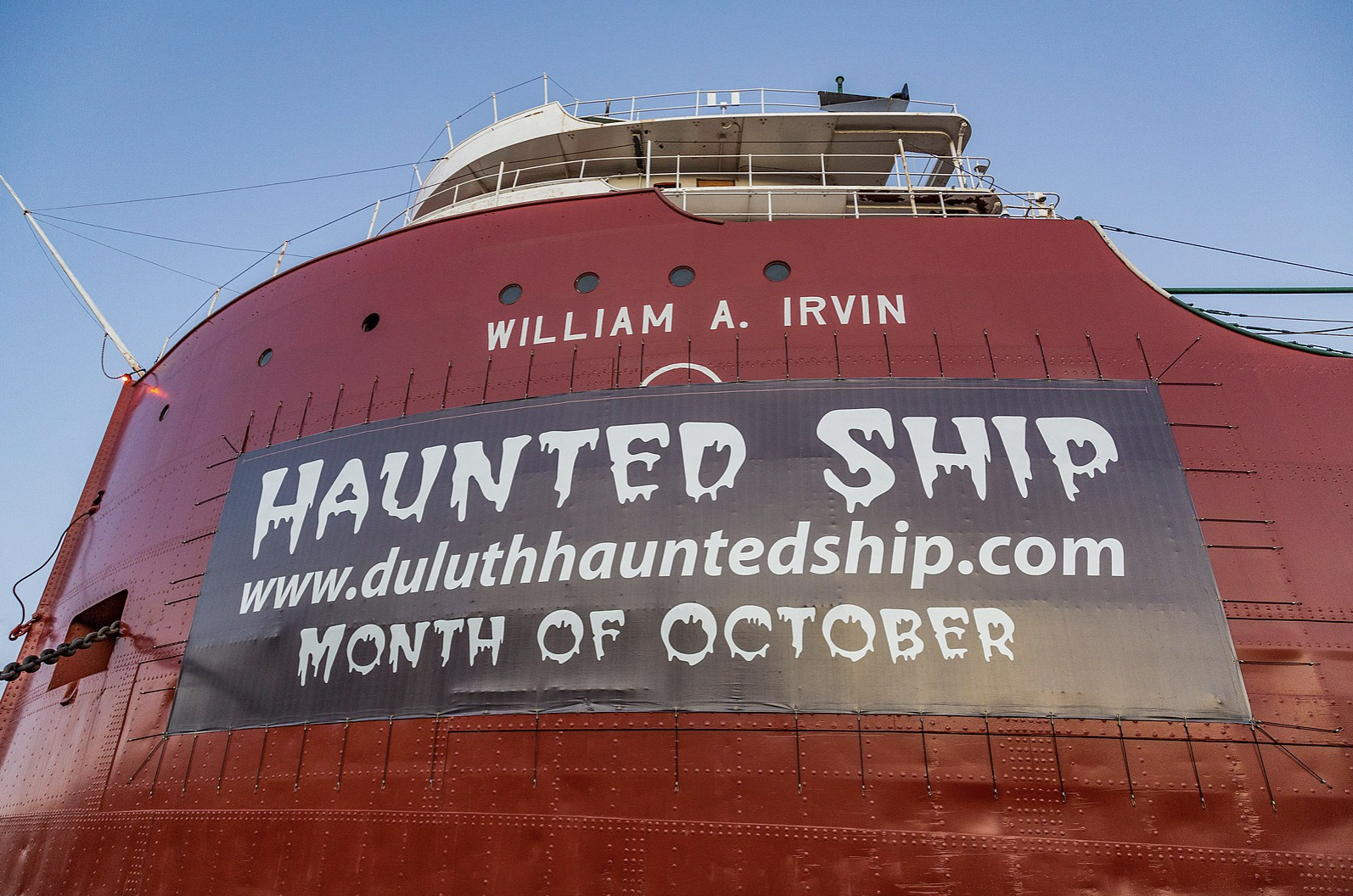 Side of red ship with banner that reads haunted ship